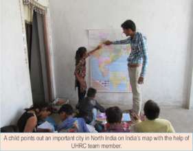 A girl points out a city on India's map