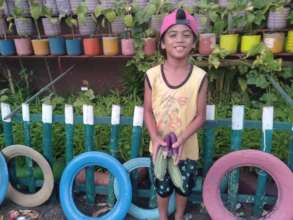 Little gardener enjoys  bounty at Salih Yusah ES