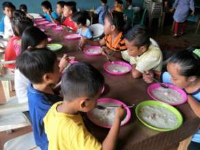 Refugee children enjoying a meal provided by AAI