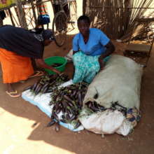 Rita poses for a photo witha customer of egg plant