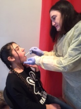 SOAR dental hygenist cleaning teeth and teaching