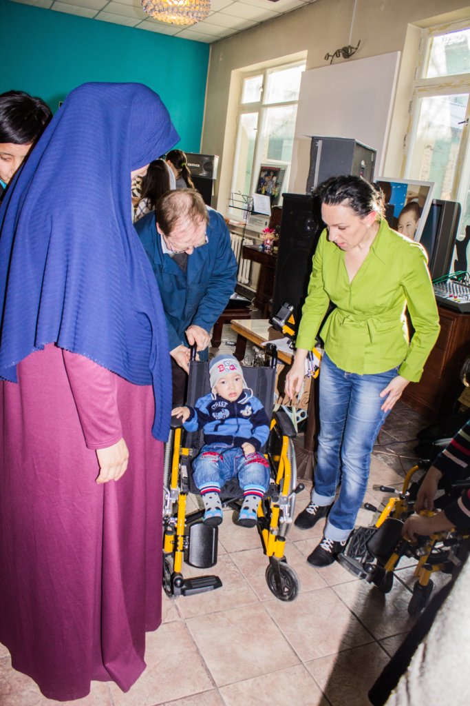 A disabled child getting a wheelchair in the cafe