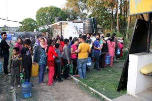 Survivors line up for clean drinking water (ECCA)