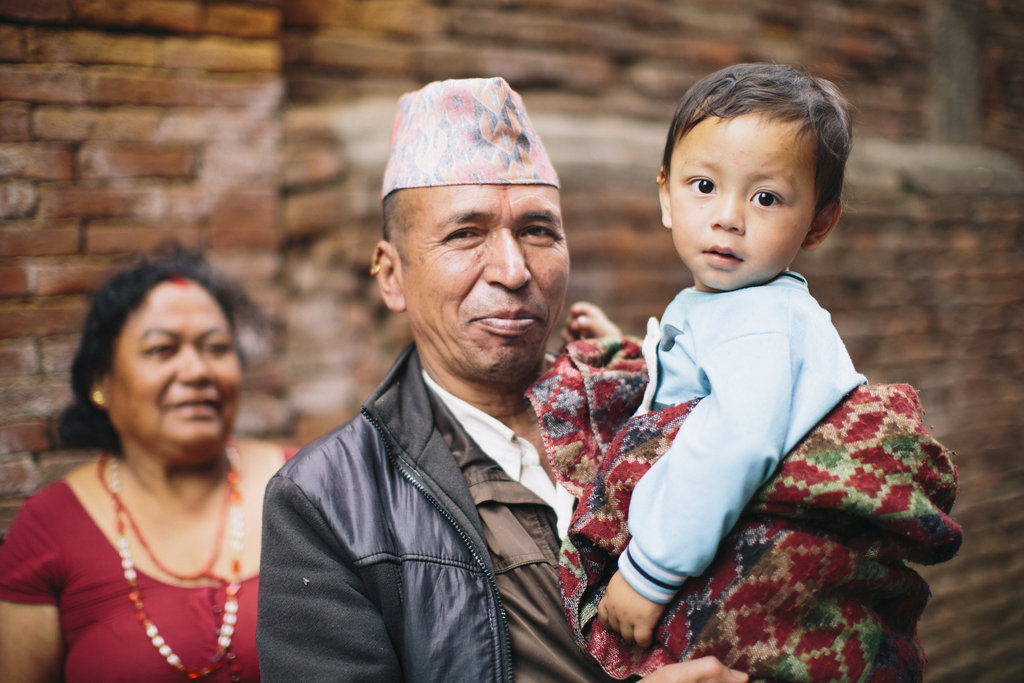 A man holds a small child and smiles