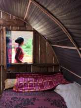 A woman stands outside her new temporary shelter