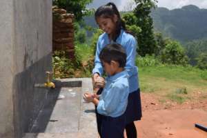 An older student helps her younger classmate