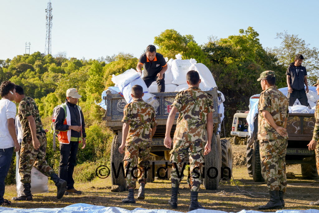 World Vision and military distributing relief item