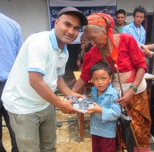 ECCA Program Officer distributing solar lamp