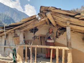 A woman in front of her cracked house