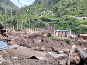Pedestrian bridge and houses damaged by the flood