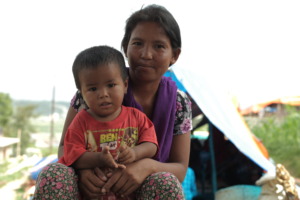 A weaver at a GoodWeave factory with her young son