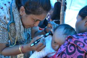 An HHC volunteer treats a young patient