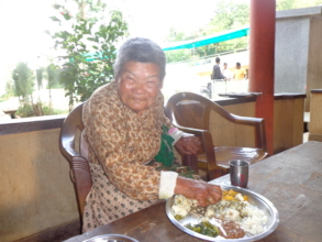 A old woman having  her meal.