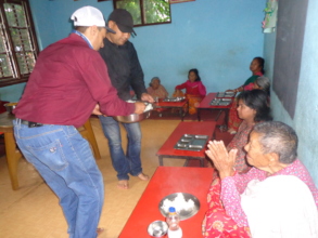 CDC chairman serving food  to the elderly people
