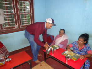 Chairman of CDC Nepal distributin milk to elderly