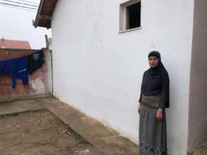 Bukurije standing in front of her house