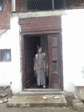 Mother Hadije standing in the doorstep