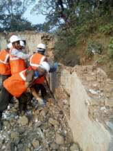 Workers demolish compromised walls of a school