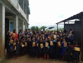 A group shot of the kids receiving raincoats