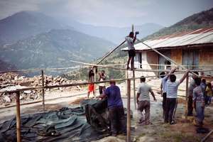 The tent frame with rubble and mountains behind