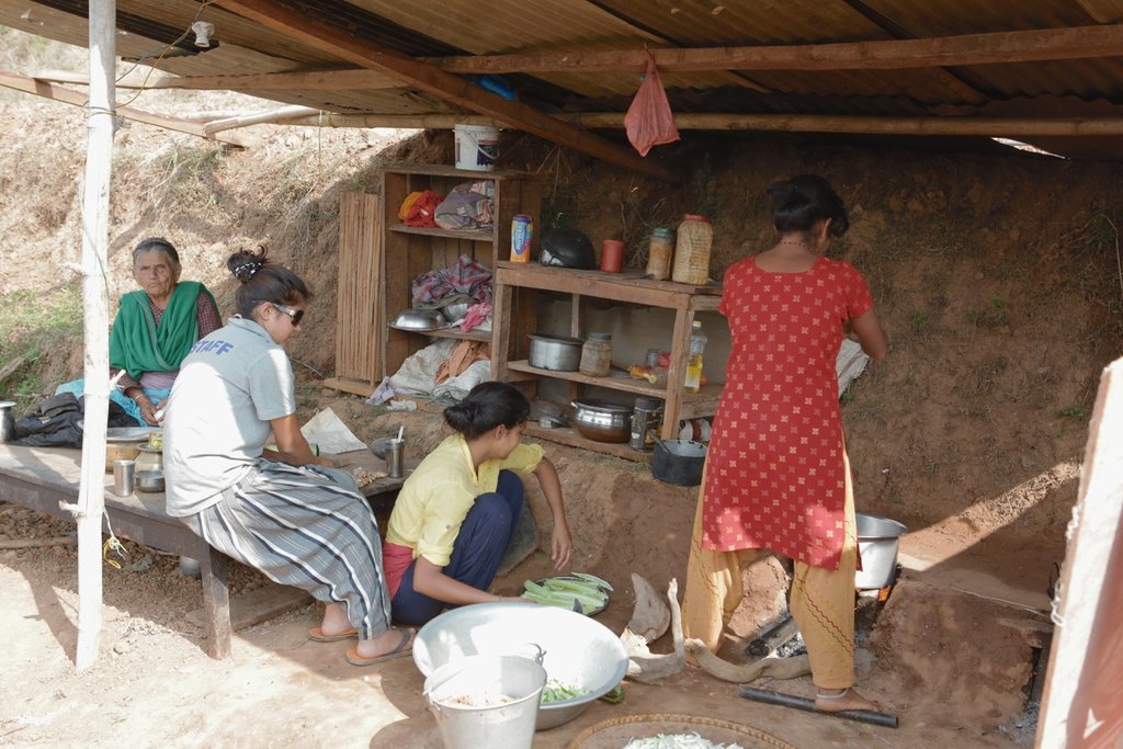 3 generations in makeshift kitchen in the village