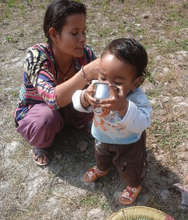 A small child drinking water from the filter