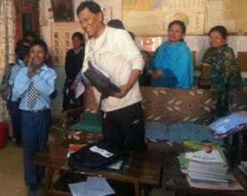 Dr Sainju from CONCERN distributes school supplies