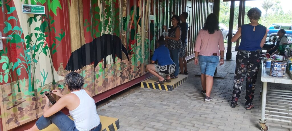 Sri sitting down to draw an armadillo