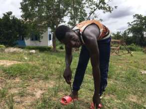 Sampson planting flowers on Afoako campus.