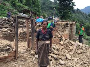 Tamang woman in front of her destroyed house.