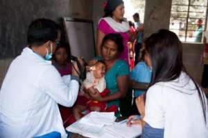 A doctor exams a child at an NRH outreach camp