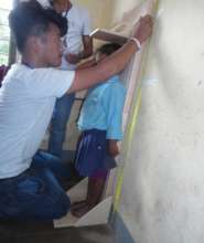 A staffer measures a young boy's height