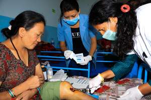Health aides tend to injured earthquake victims