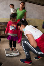 Standing tall...NYF staffer measurers a young girl