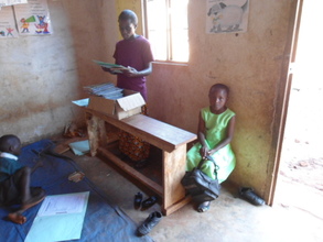 Teacher Annet helping Baby Class kids.