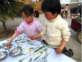 Children make a poster with twigs and leaves.