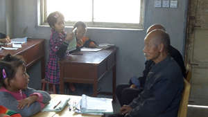 Students interview an elderly villager.