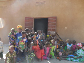 Girls sitting in front of their classroom