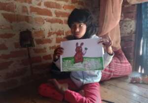 Laxmi showing her drawing of a rabbit with carrot