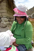 Escolastica plays with a young community member