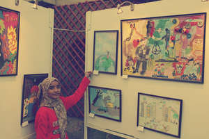 A child with her artwork in the exhibition