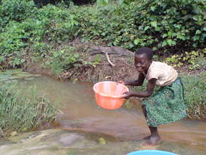 Girl Collecting Water with Crocodile in Background