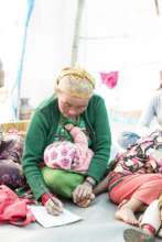 A mother multi-tasks during literacy class.