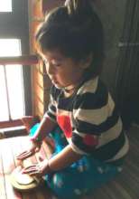 Ganga likes to help roll out dough for chapati.