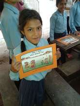 A girl at refugee camp shows her copy of the book