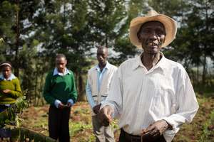 Students instructing local farmer on composting