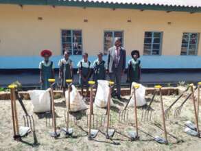 Headmaster and  pupils with tools, seeds and more