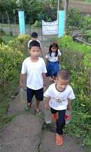Small students carry water up a steep hill daily