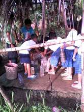 students fill school wash area with hauled water