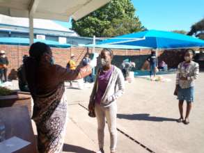 Students receive groceries + temperature checks